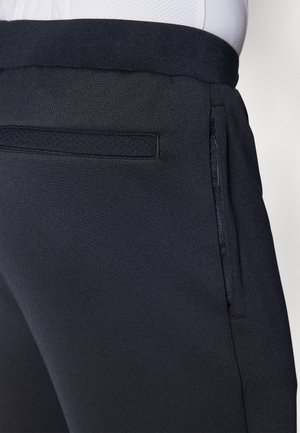 Pantalones deportivos azul oscuro con un tejido suave y texturizado, cintura elástica y un bolsillo lateral con cremallera para mayor comodidad.