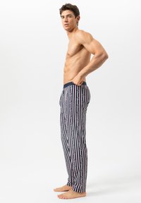 Marineblauwe broek met verticale strepen en grafische accenten. Gemaakt van zacht materiaal, voorzien van een elastische tailleband en een relaxte pasvorm.