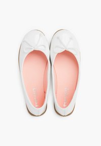 Ballerine bianche con finitura lucida, soletta rosa chiaro e dettaglio in pizzo a fiocco sulla punta. La suola presenta un colore marrone chiaro.
