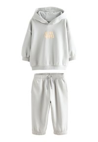 Felpa grigia con cappuccio e grafica testuale "Cool Vibes", abbinata a pantaloni jogger grigi coordinati con vita e polsini elasticizzati.