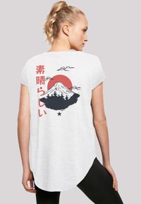 White short-sleeve t-shirt featuring a graphic of Mount Fuji, red sun, clouds, and Japanese text on the back. Soft fabric, relaxed fit.