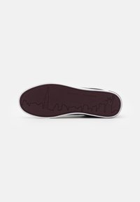 Sole di scarpa in gomma marrone scuro con un bordo bianco, caratterizzata da un design di skyline che include l'Empire State Building e la Statua della Libertà.