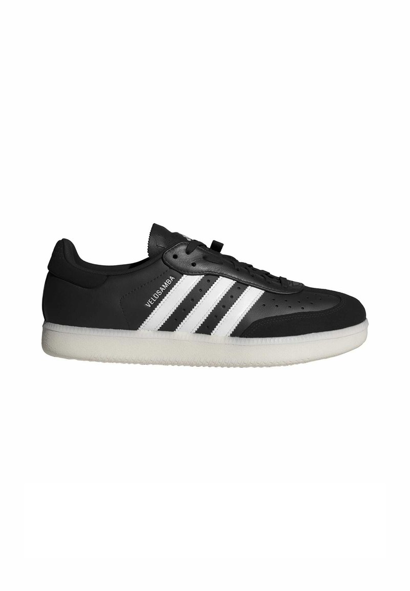 Czarne skórzane sneakersy z trzema białymi paskami, perforowana cholewka, sznurowane zapięcie oraz biała gumowa podeszwa z teksturowanym wzorem bieżnika.