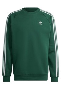Grön Adidas sweatshirt med vita tre ränder längs ärmarna och liten vit Adidas trefoil-logga på vänster bröst.