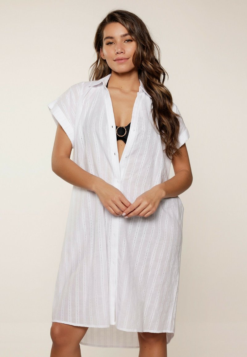 Abito camicia bianco, lunghezza ginocchio, con maniche corte, righe verticali e chiusura a bottoni. Tessuto leggero, vestibilità casual, non foderato.