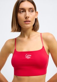 Rood katoenen bralette met dunne bandjes, voorzien van een vierkante halslijn en geborduurd logo aan de voorkant, gladde textuur en aansluitend ontwerp.