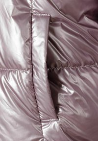 Pufasta jakna u sjajnom mauve materijalu, sa bočnom džepom integriranim u quiltani dizajn s vidljivim detaljima šivanja.