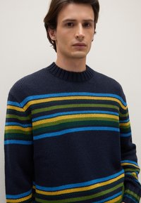 Marineblauer Strickpullover mit mehrfarbigen Streifen in Blau, Grün und Gelb. Rundhalsausschnitt und gerippte Saumdetails.