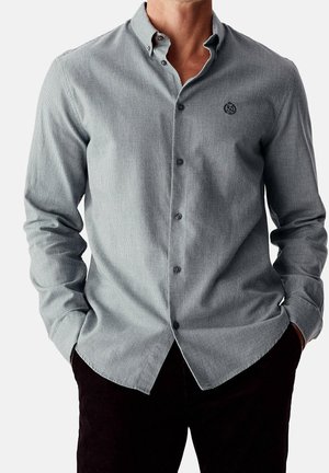 Chemise à boutons gris clair avec un petit motif à carreaux. Dotée d'un col moyen, de manches longues et d'un logo sur la poitrine.