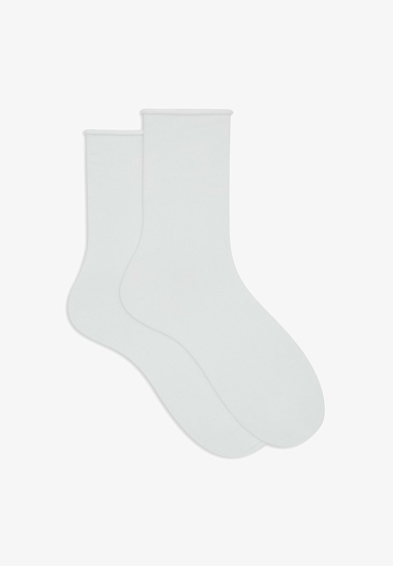 Un paio di calzini bianchi di lunghezza media disposti appiattiti, sovrapponendosi leggermente, su uno sfondo bianco.