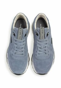 Lichtblauwe suède sneakers met een afgeronde neus, vetersluiting en zwarte accenten aan de zijkanten en op de tong. Rubberen buitenzool met grip.