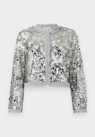 Κοντό σακάκι από διάφανο ασημί ύφασμα καλυμμένο με παγιέτες. Διαθέτει στρογγυλή λαιμόκοψη, κλείσιμο με κουμπιά και περιθώρια με φουντίτσες.