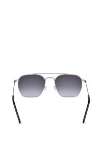 Lunettes de soleil à monture en métal argenté, verres dégradés foncés et branches courbées noires, vues de face sur fond blanc.