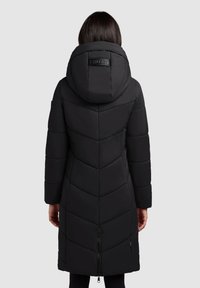 Manteau en duvet noir avec capuche, présentant un design matelassé en chevrons, une fermeture éclair à l'avant et un accent logo à l'arrière de la capuche. La longueur atteint le mollet.