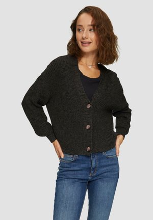 Cardigan en tricot noir avec un col en V, doté de cinq boutons marron, de manches longues et d'une coupe décontractée, associé à un jean bleu.