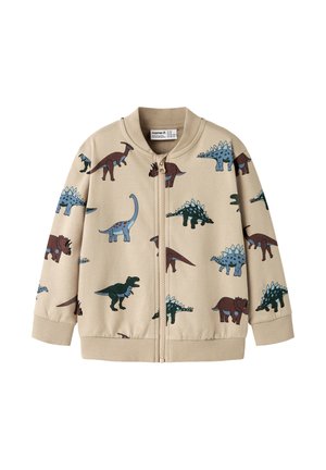 Beige Kinderjacke mit Reißverschluss mit blauen und braunen Dinosaurierillustrationen sowie gerippten Bündchen und Kragen.