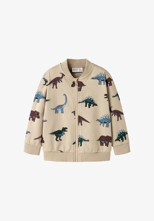Veste zippée beige pour enfants avec illustrations de dinosaures bleus et marron, poignets et col côtelés.