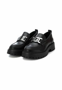 Zapatos de cuero negro sin cordones con una suela de goma gruesa, que cuentan con un acento decorativo de cadena plateada a través del empeine y un diseño de punta redondeada.