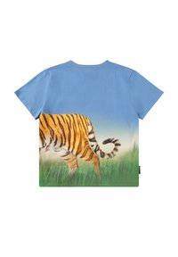 Niebieska koszulka z realistycznymi tylnymi nogami i ogonem tygrysa, idącego przez zieloną trawę pod czystym niebem na plecach.
