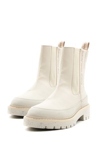 Stivali bianchi alla caviglia con finitura liscia, pannelli laterali elasticizzati e una suola chunky maculata. Presenta un logo sulla linguetta posteriore del tallone.