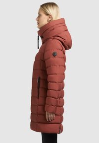 Parka rossa gonfiata con colletto alto e cappuccio attaccato, caratterizzata da cuciture orizzontali, una patch con logo sulla manica e tasche laterali con zip.