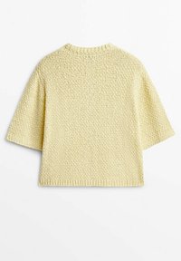 Jasnożółty, dziergany top z krótkimi rękawami i okrągłym dekoltem. Posiada strukturalny wzór i luźny krój.