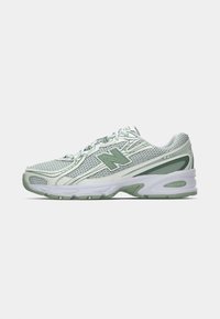 Valge ja helesinine New Balance jooksutoss, millel on võrgust ülemine osa, kummist tald ja logo küljel, vaadatuna välimiselt küljelt.