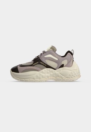 Zapatilla baja con suela gruesa y texturizada, malla beige y gris con superposiciones negras y marca "Armani Exchange" en los laterales y en la lengüeta del talón.