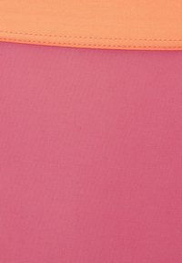 Roze stof met een gestructureerd oppervlak, bedekt met een gladde oranje stof langs de rand, gestikt voor duurzaamheid.