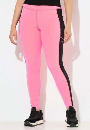 Leggings sportivi rosa con pannelli laterali neri, design aderente e cuciture a contrasto. Abbinati a sneakers nere.