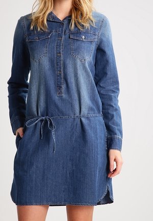 Abito di jeans con maniche lunghe, chiusura frontale a bottoni, due tasche sul petto, vita regolabile con coulisse e orlo leggermente curvato in diverse sfumature di blu.