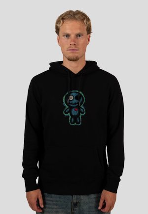 Hoodie nero con una grafica di una figura simile a un orso con un cuore ricamato, dettagliato in ricami blu e verde, materiale in cotone, vestibilità comoda.