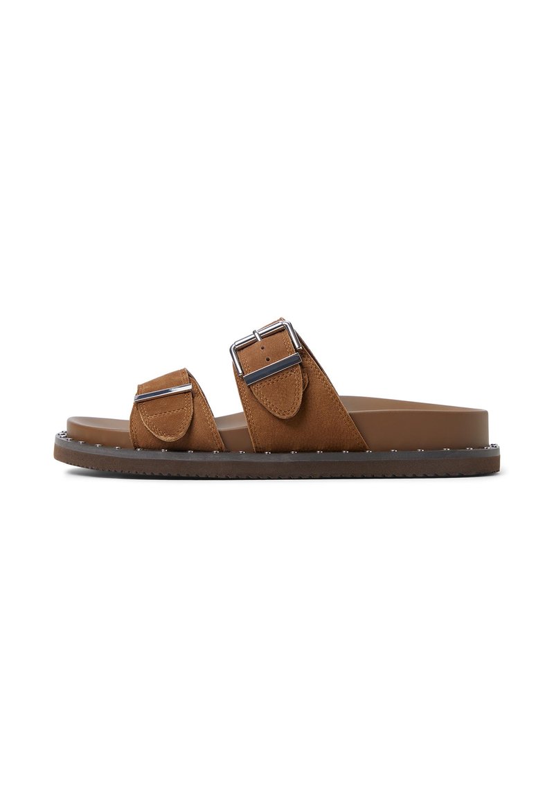 Sandales en nubuck marron avec deux brides ajustables, boucles métalliques et une semelle texturée. Elles disposent d'un pied plat et d'un bord clouté.