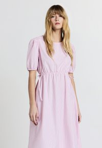 Vestito a strisce rosa chiaro con maniche a sbuffo corte e vita aderente, dotato di lacci laterali per la regolazione e una gonna fluida.