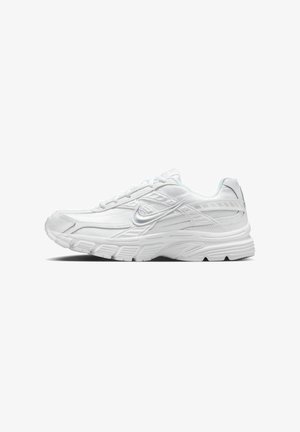 Zapatilla deportiva blanca con suela texturizada, parte superior de malla y sintética, y un logo plateado de Nike swoosh en el lateral.