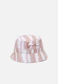 Cappello a secchiello caratterizzato da un motivo ondulato rosa e bianco, realizzato in tessuto con una texture liscia, decorato con una firma rossa a contrasto.