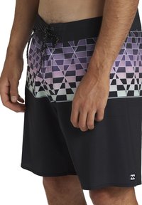 Svarta simshorts med ett lila och grönt geometriskt mönster på midjan, med dragsko-stängning och strukturerad tyg.