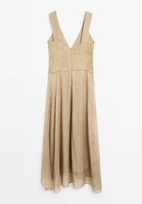 Beige midi dress ilman hihoja, jossa on leveät hihnat, istuva yläosa ja vapaa helma, roikkumassa valkoista taustaa vasten.