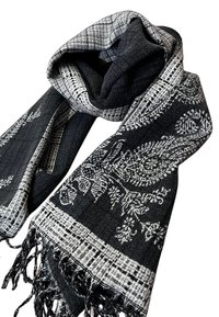 Sciarpa nera e grigia caratterizzata da un motivo paisley, texture intrecciata e bordi frangiati. Il design fonde sezioni di tessuto solide e a quadri.