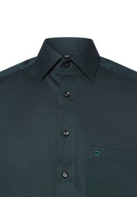 Chemise à boutons vert foncé en tissu texturé, avec deux boutons noirs, une poche poitrine unique et des détails contrastants au col et aux épaules.