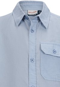 Camicia button-up azzurro chiaro realizzata in tessuto testurizzato, caratterizzata da un colletto a punta, tasca frontale e bottoni blu. Logo sulla tasca.