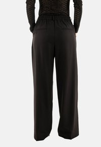 Pantaloni neri a gamba larga con vita elasticizzata, tasche posteriori e tessuto morbido e leggero. Design semplice e funzionale.