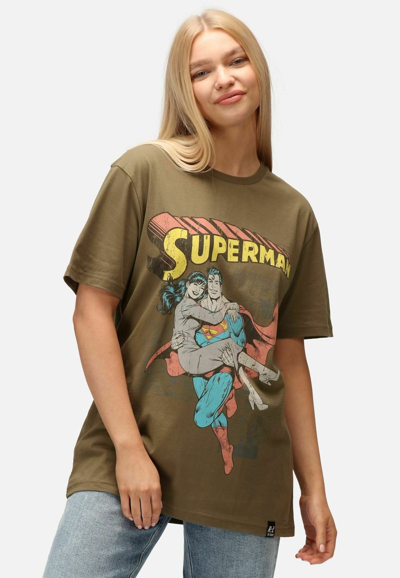 Camiseta de algodón verde oliva con un gran gráfico de Superman en azul, rojo y gris, con un corte relajado y mangas cortas.