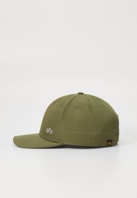 Olivengrønt kasket med struktureret design, flad skygge og frontbroderet logo. Har ventilationsøjer og et lille mærke på siden.
