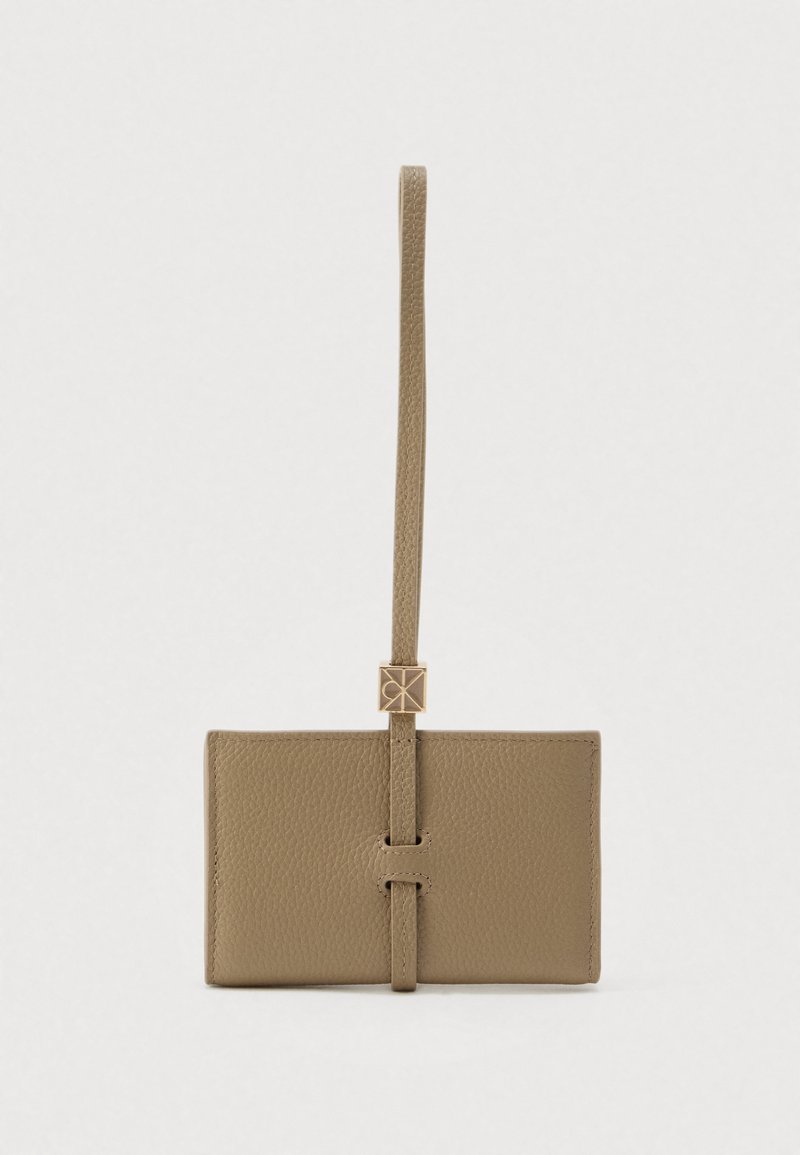 Δερμάτινο πορτοφόλι σε απαλό μπεζ χρώμα, με υφή στην επιφάνεια, λαβή σε σχήμα θηλιάς και κούμπωμα σε χρυσή απόχρωση. Συμπαγής ορθογώνιος σχεδιασμός.