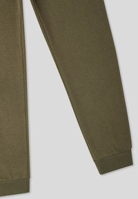 Oliwkowe spodnie dresowe wykonane z miękkiego materiału bawełnianego, z tapered kształtem i prążkowanymi ściśnięciami w kostkach.