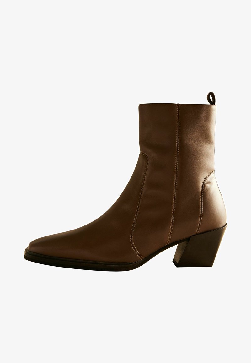 Bruine leren enkelboot met een spitse neus, diagonale naaddetails en een dikke, taps toelopende hak. Gegoten oppervlak met een gladde afwerking.