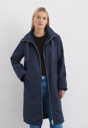 Marineblauwe lange jas met een hoge kraag, ritssluiting en twee voorzakken. Bevat bijpassende banden en een gladde, waterbestendige textuur.