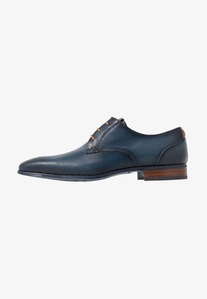 Chaussure de ville pour homme en cuir texturé bleu marine avec lacets marron, bout rond, petit talon et semelle lisse marron et noire.