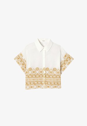 Chemise blanche à manches courtes boutonnée avec col pointu, présentant des motifs floraux et géométriques jaunes sur les manches et la partie inférieure.